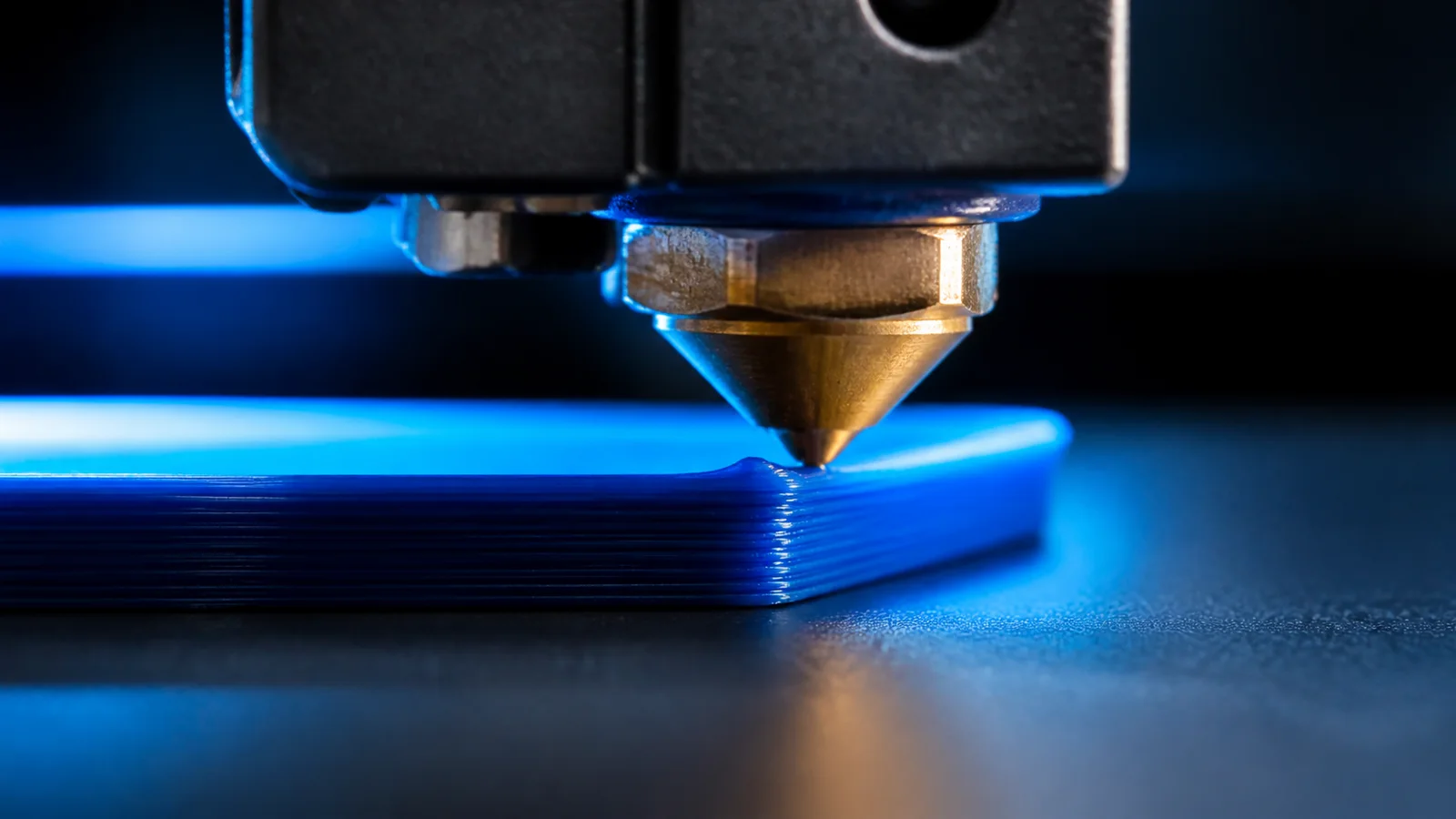 3D yazıcı nozzle ucunun yükselmiş baskı kenarına yaklaştığı ayrıntılı makro sahne